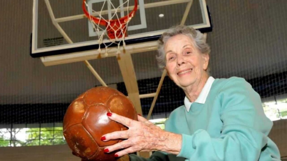 Idosa com bola de basquete em frente à cesta