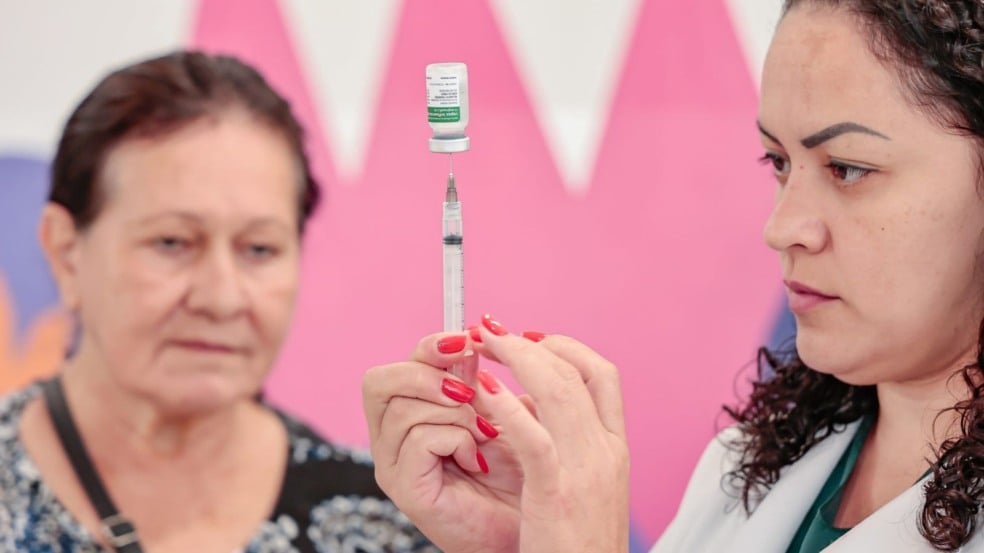 Mulher com vacina na mão