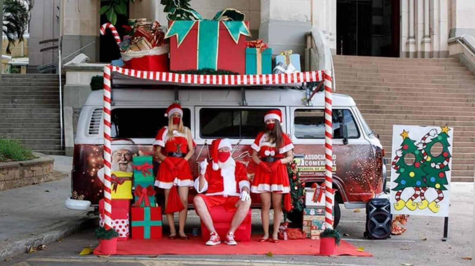 Kombi de Natal da ACE Jundiaí, com papai noel e noeletes em frente à igreja