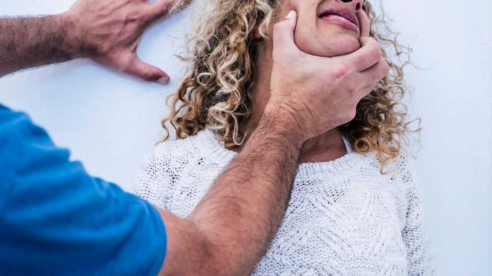 Homem empurrando mulher contra a parede