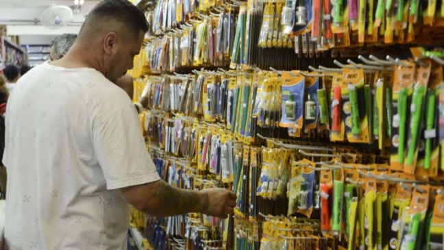 Homem ao lado de canetas e lápis - Lista de Material