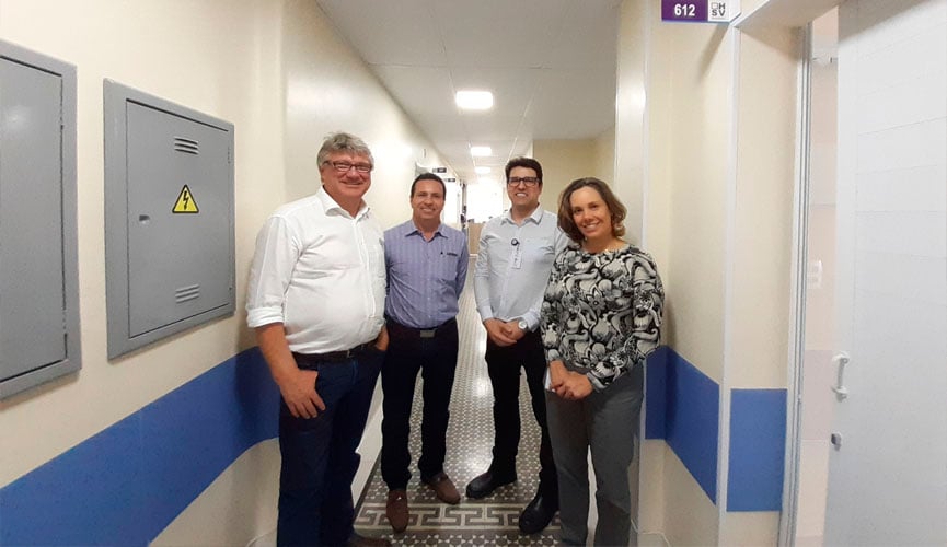 Quatro pessoas em pé, sendo três homens e uma mulher, em corredor do hospital são vicente de paulo, em jundiaí