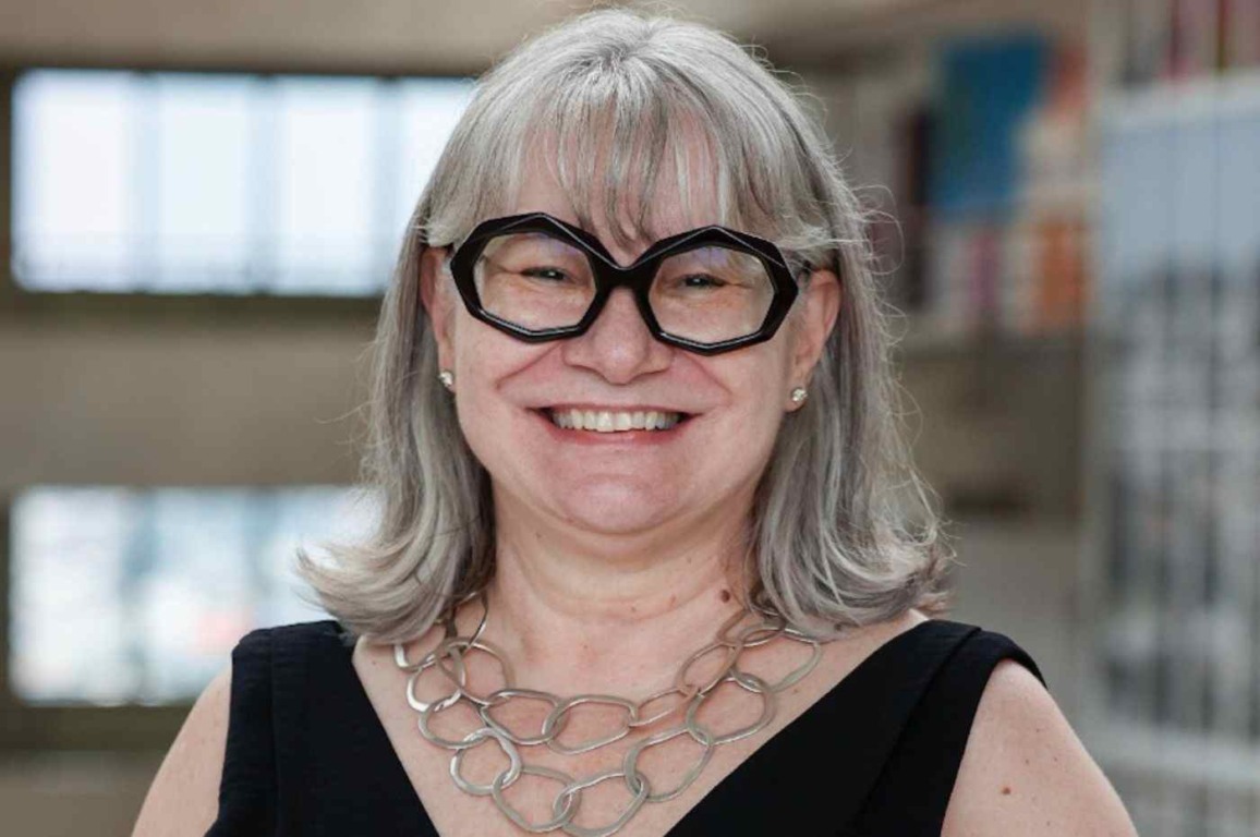 Dra. Márcia Facci, de cabelos grisalhos, óculos pretos e colar prateado, sorrindo ao assumir a gestão da saúde em Jundiaí.