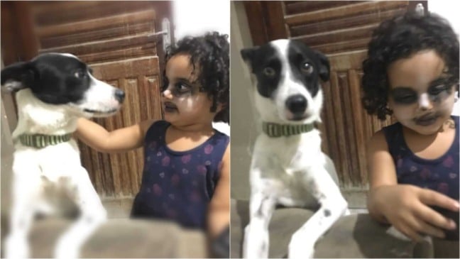 Menina de rosto pintado ao lado de cachorro