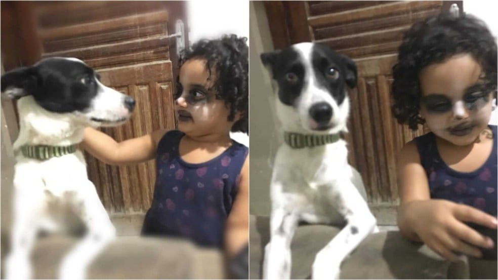 Menina de rosto pintado ao lado de cachorro