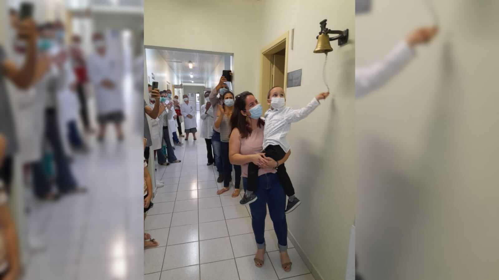 Miguel, de 4 anos, ao lado da mãe Márcia, tocou o sino da vitória no Grendacc e comemorou o fim do tratamento efetivo contra um câncer raríssimo