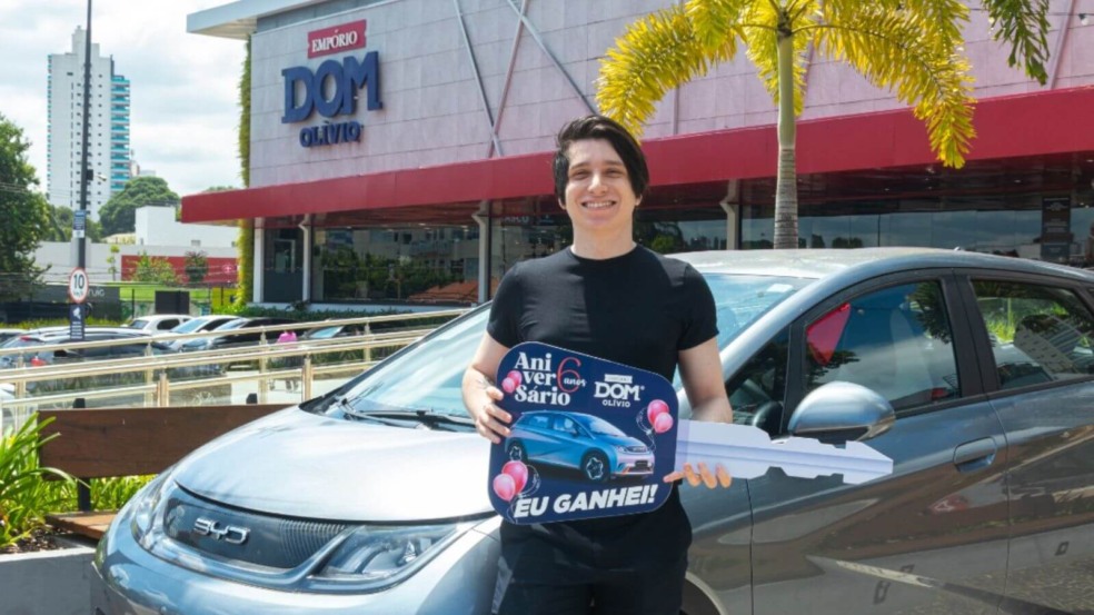 Morador de Jundiaí com carro elétrico em frente ao Empório Dom Olívio