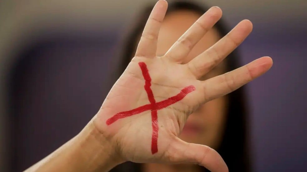 Mao de mulher com um X