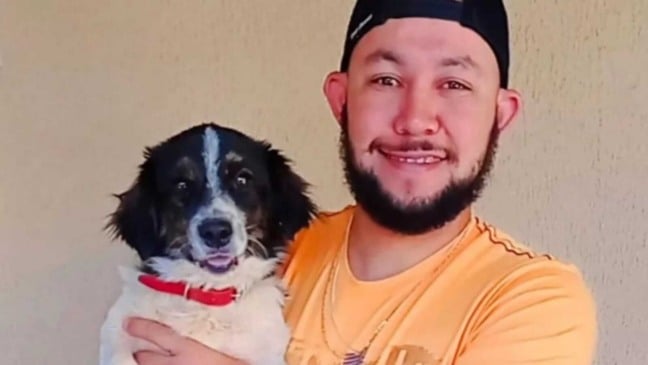 Homem segurando cachorro