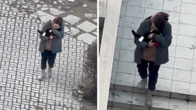 Mulher carregando gato no colo