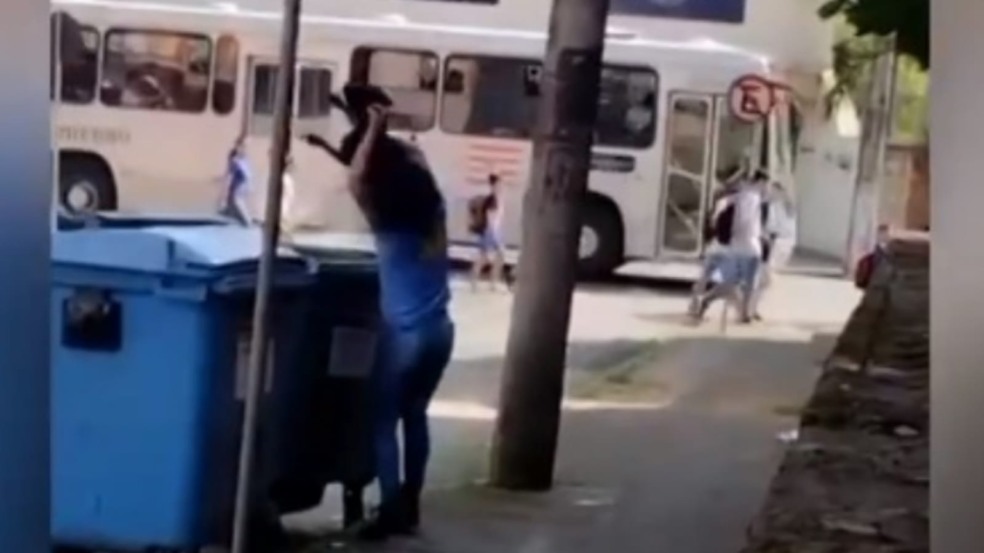 Mulher jogando cachorro em lixeira