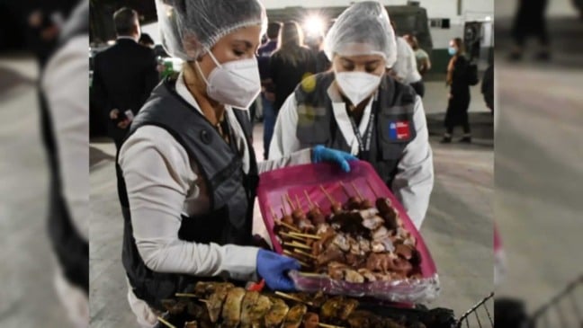 Mulheres segurando caixa com espetinhos Mulheres segurando caixa com espetinhos