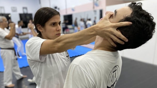 Mulher aplicando golpe