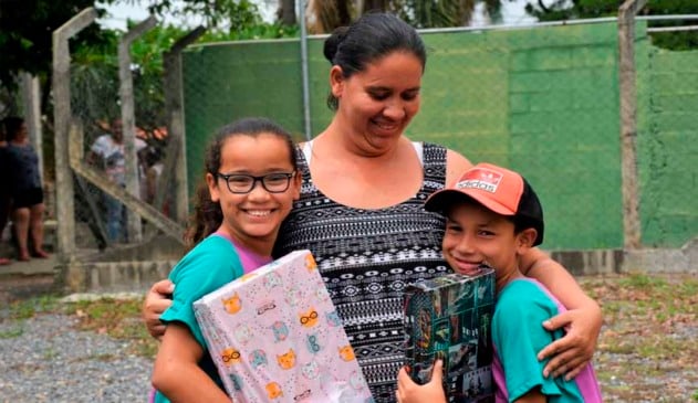 mãe com filho e filha crianças segurando pacotes de presentes