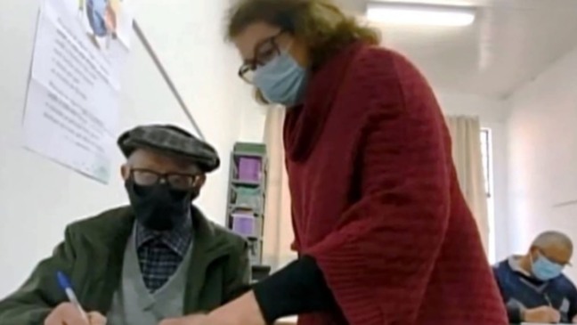 Professora atendendo aluno idoso em Santa Catarina