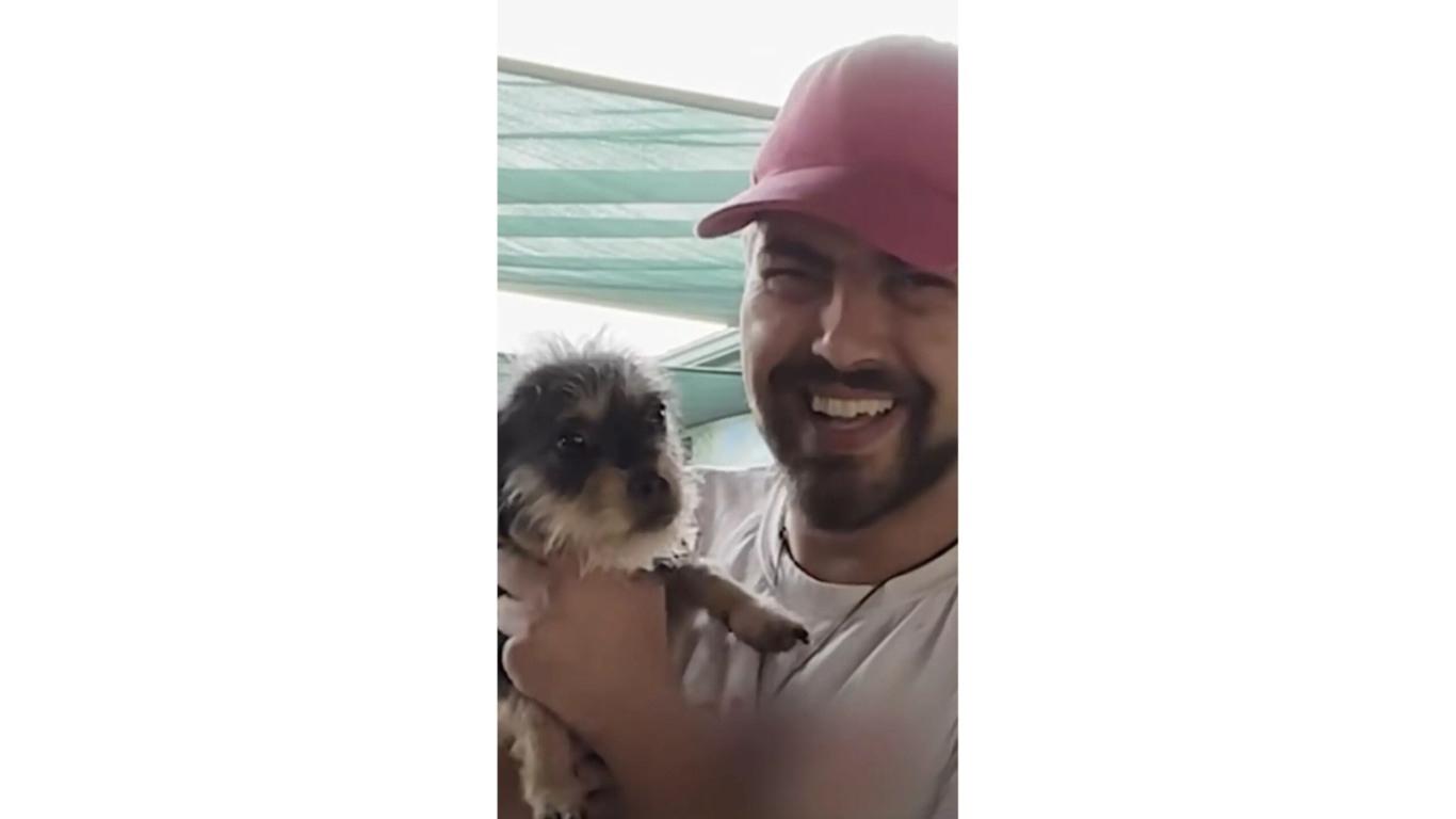 Homem com cachorro no colo