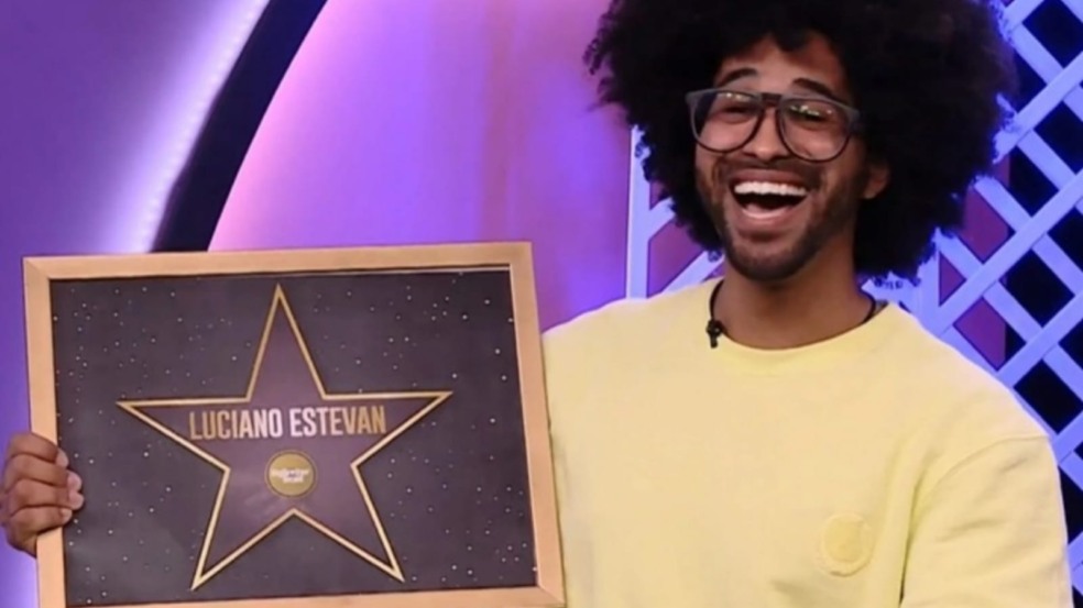 Luciano do BBB22 segurando uma placa com estrela e seu nome no centro