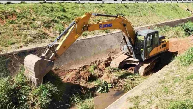 Escavadeira realiza desassoreamento em córrego de Jundiaí para prevenir enchentes.