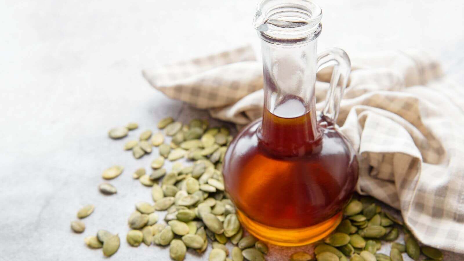 Sementes e garrafa com óleo de semente de abóbora