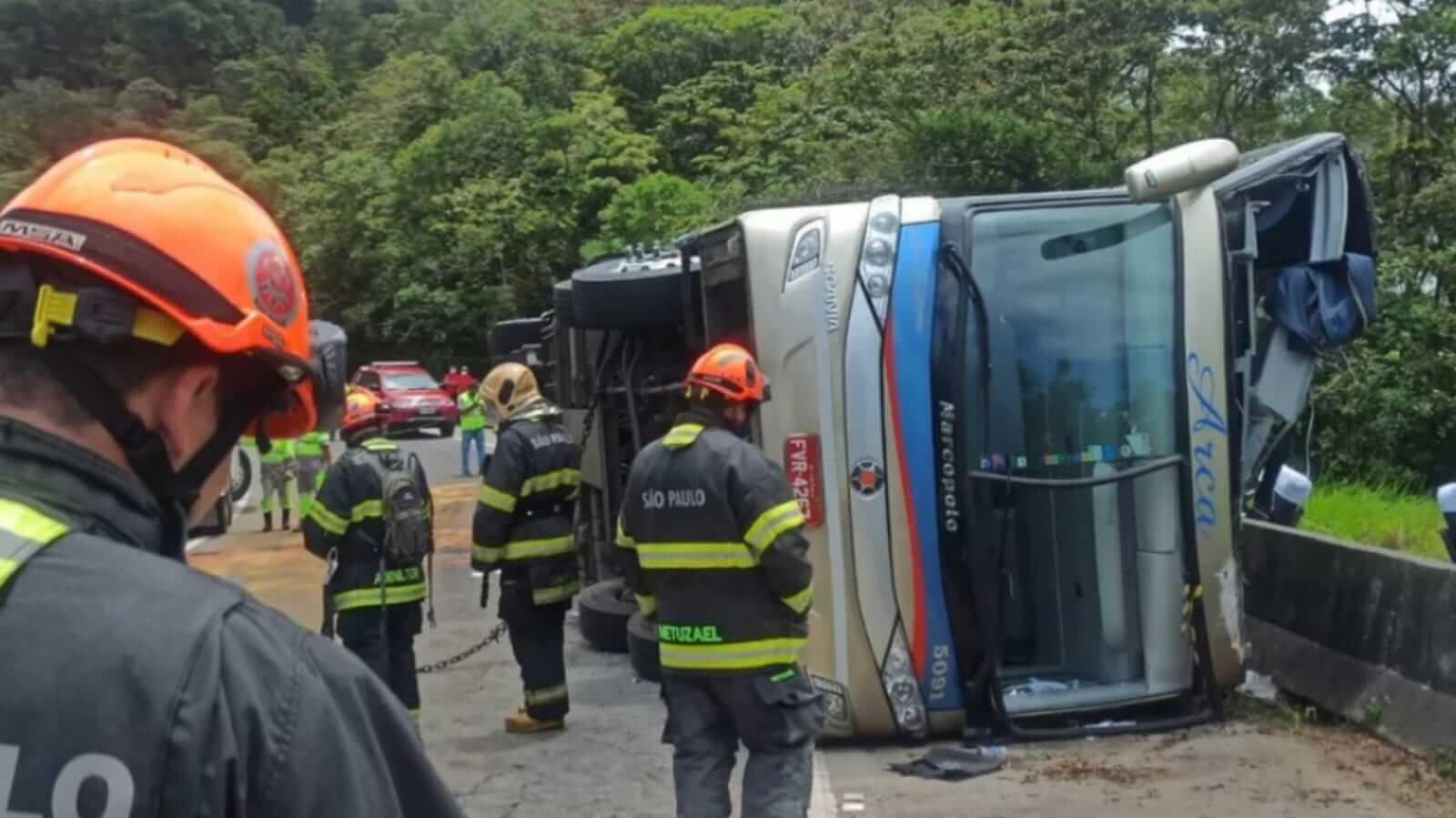 Ônibus tombado em rodovia com bombeiros em volta