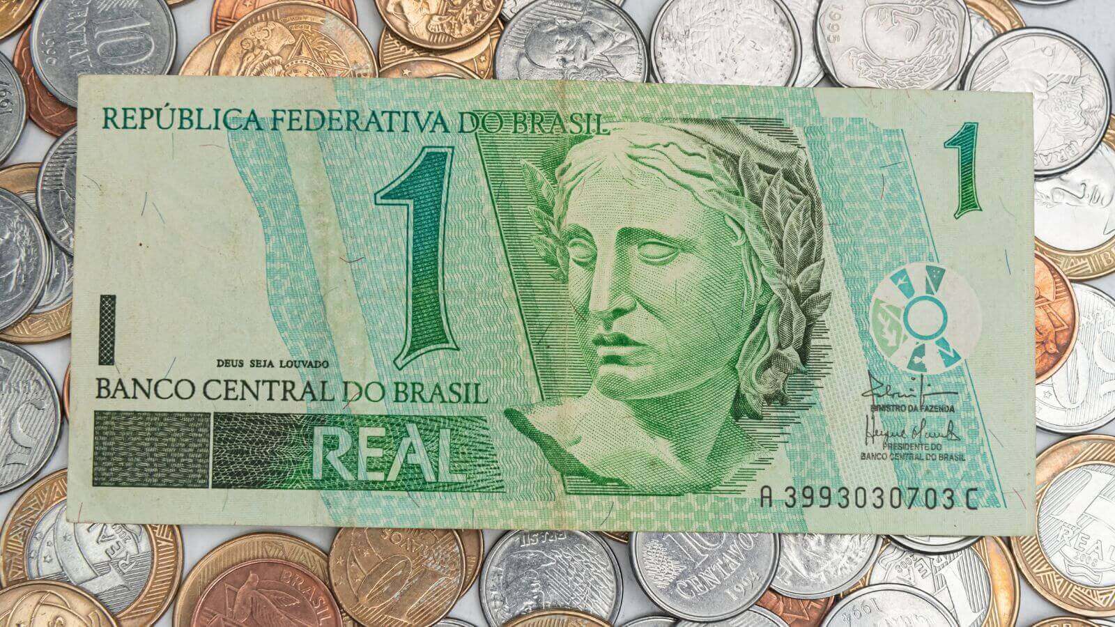 Cédula de um real e moedas do Brasil