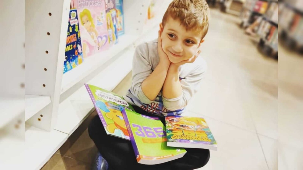 Menino sentado com livros