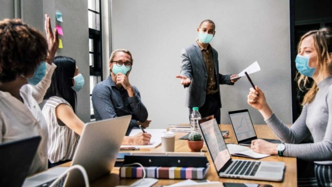 Pessoas de máscara em escritório