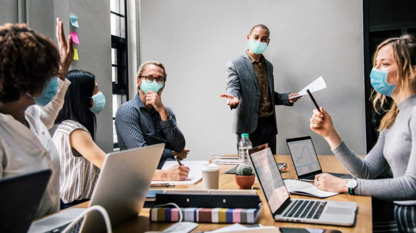 Pessoas de máscara em escritório