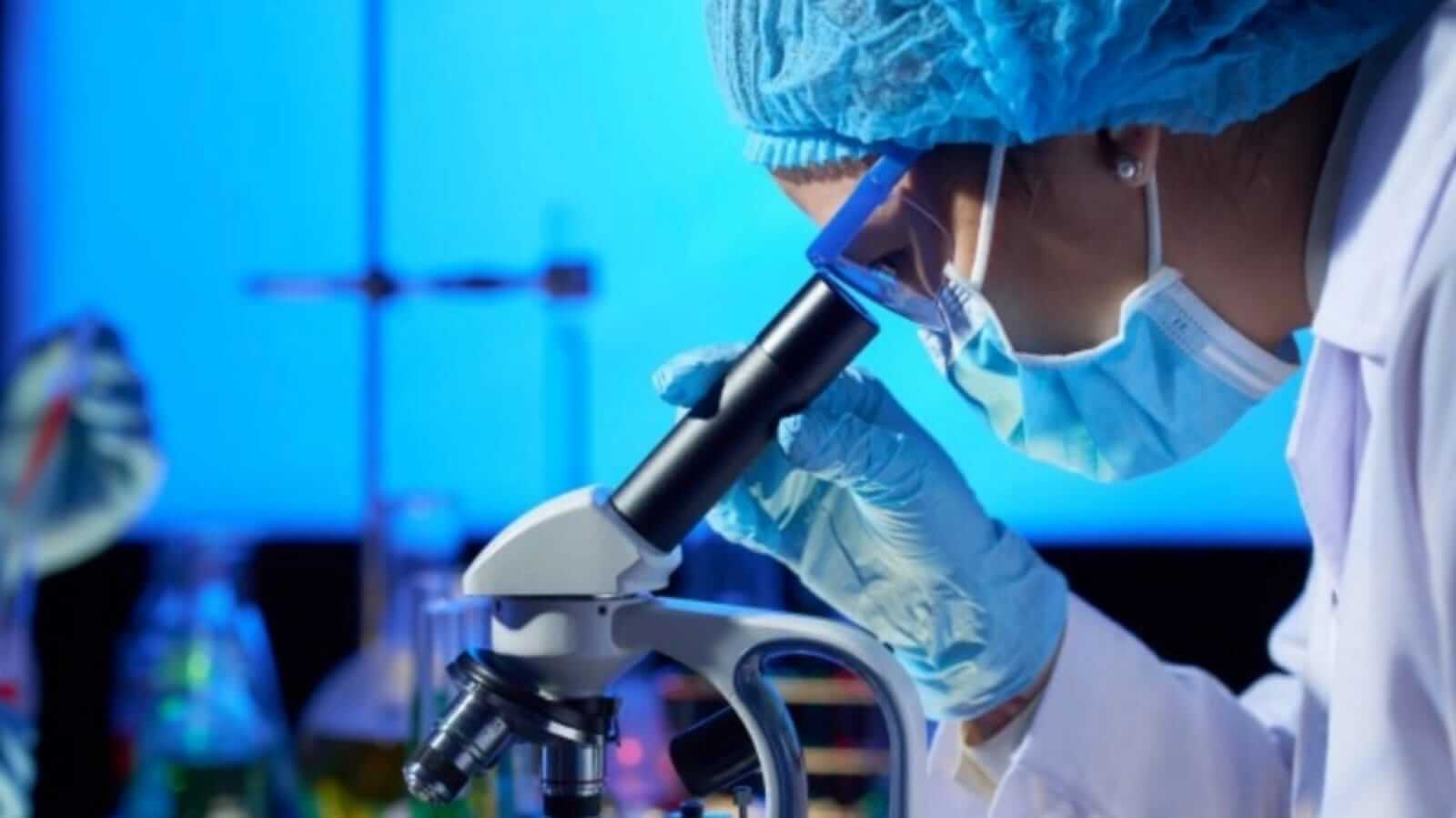 Mulher usando microscopio