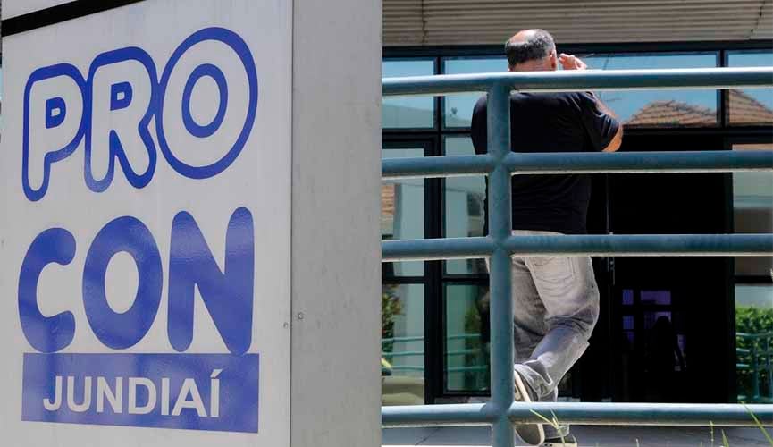 Metade da foto mostra muro em frente ao procon jundiaí com os dizeres "Procon Jundiaí". Outra metade mostra, ao fundo, homem adentrando o local