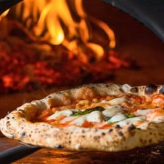 Pizza napoletana saindo do forno à lenha