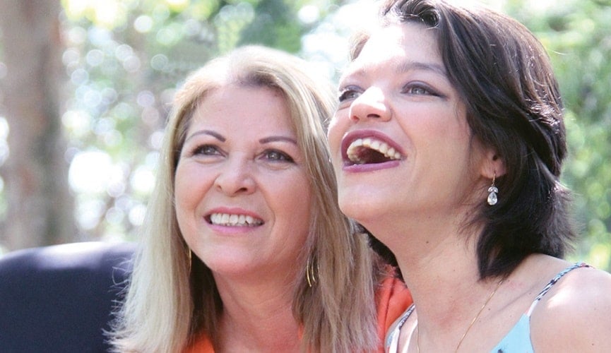 Foto de mulher loira e mulher de cabelos escuros sorrindo