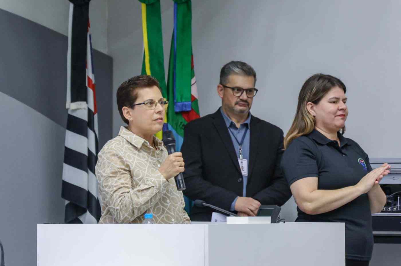 Secretária Rita Orsi discursa durante a apresentação do Plano Municipal do Esporte em Jundiaí, ao lado de intérprete de Libras.