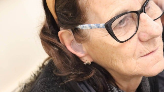 Mulher com aparelho auditivo