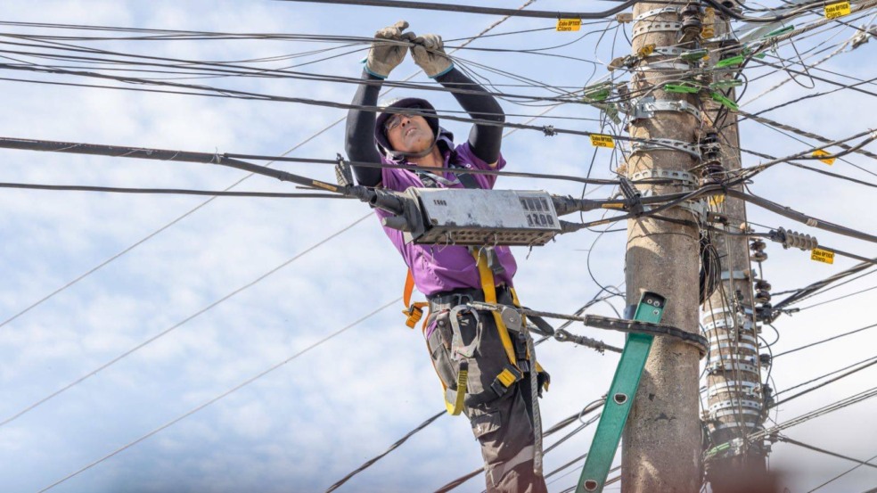 Homem ordenando cabos em poste Homem ordenando cabos em poste