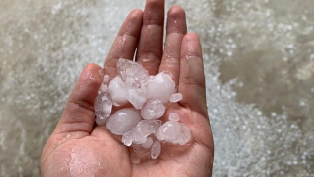 Mão com granizo após chuva