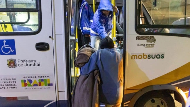 Pessoa entregando cobertor para outra