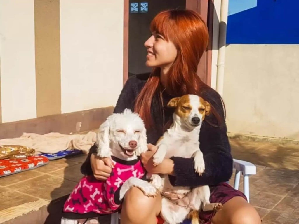 Mulher com dois cachorros no colo