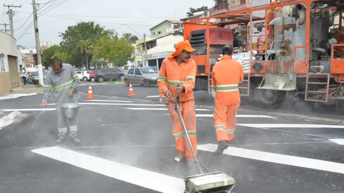 Homens sinalizando ruas asfaltadas em Jundiaí