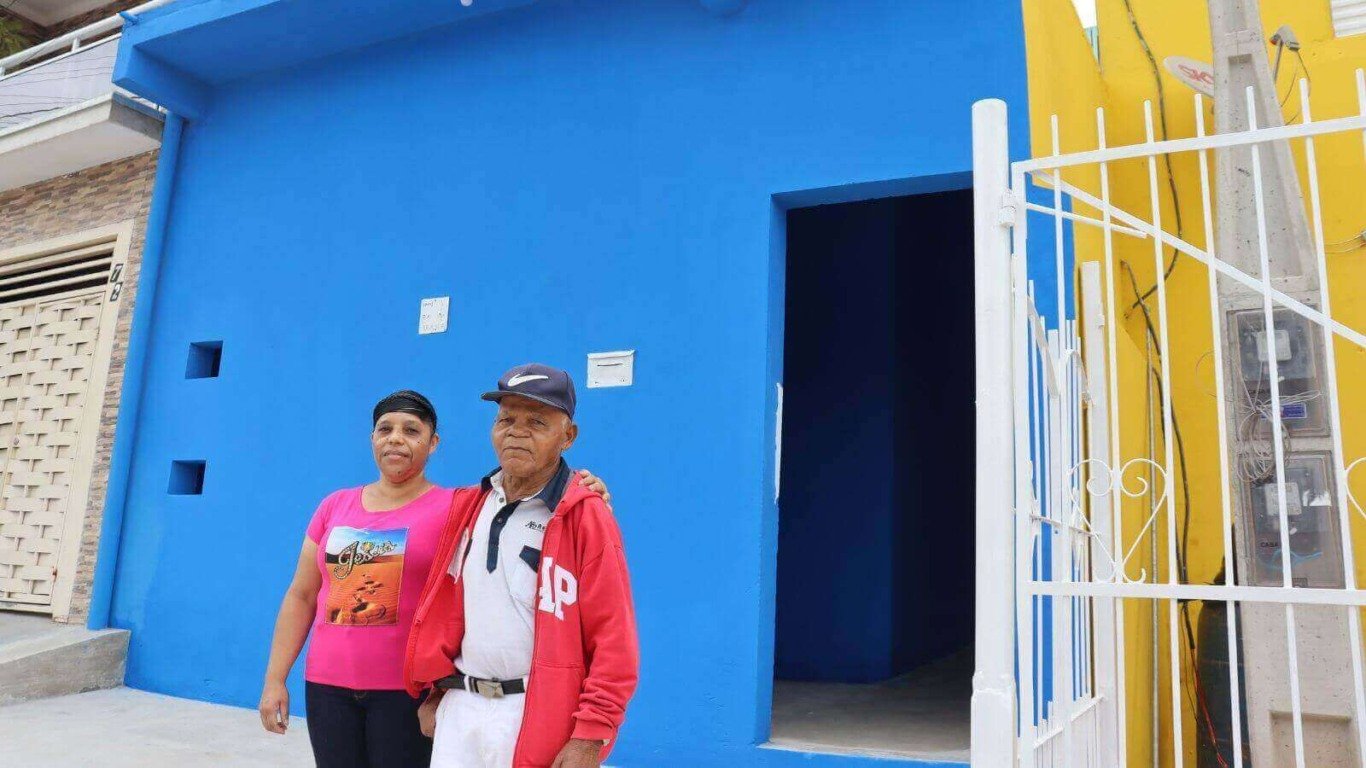 Homem e mulher em frente à casa azul