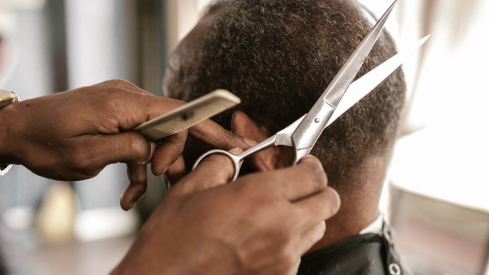 Homem cortando cabelo de outro homem