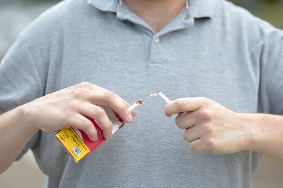Homem quebrando cigarro