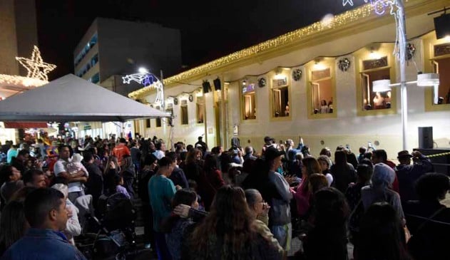 pessoas acompanham coral em janelas de construção em estilo colonial