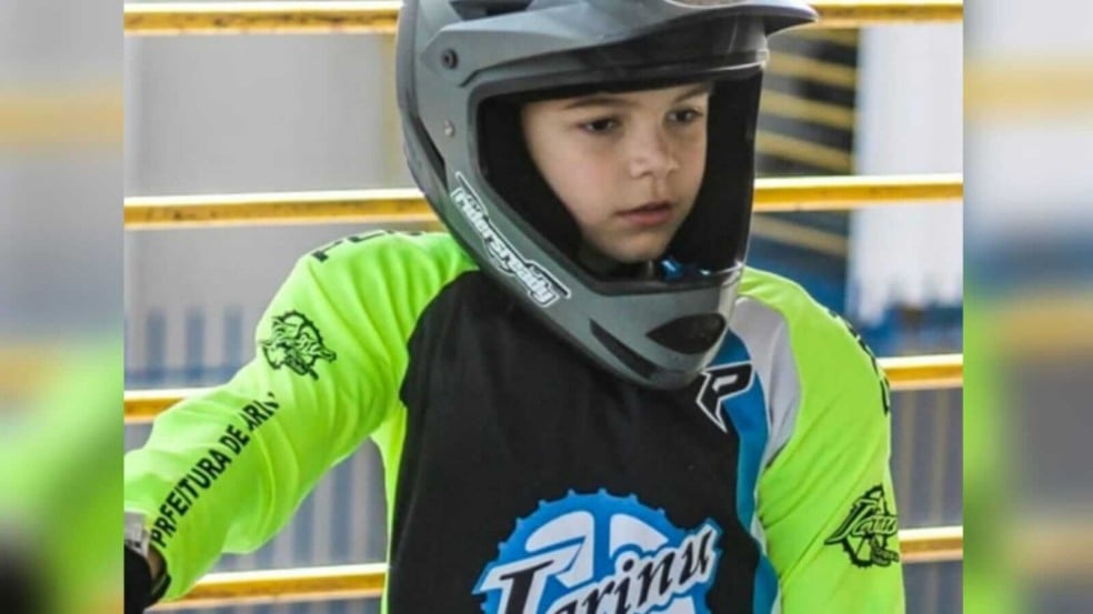 Menino com uniforme e capacete e BMX