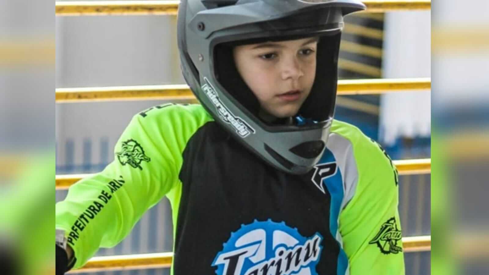 Menino com uniforme e capacete e BMX