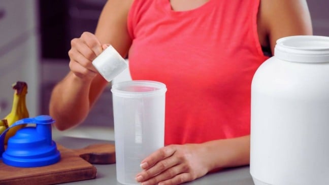 Mulher preparando bebida de proteína