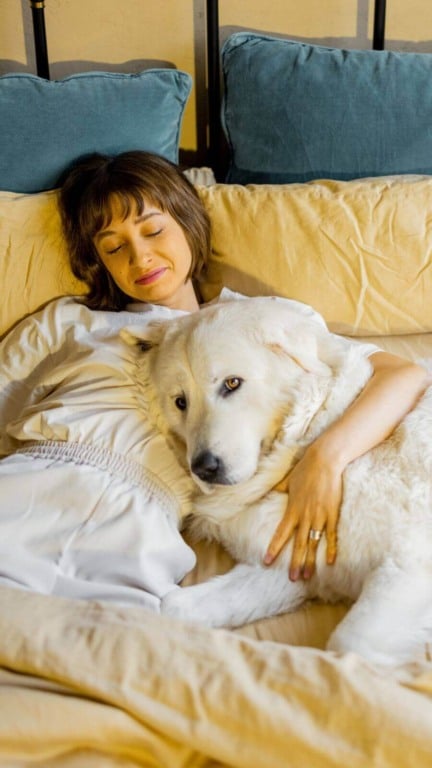 Mulher dormindo com cachorro