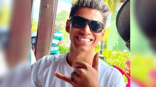 Foto de jovem com óculos escuros sorrindo