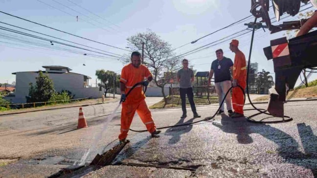 Trabalhador da Prefeitura de Jundiaí faz limpeza de boca de lobo com mangueira de alta pressão no bairro Vila Ana, como parte das ações de revitalização.