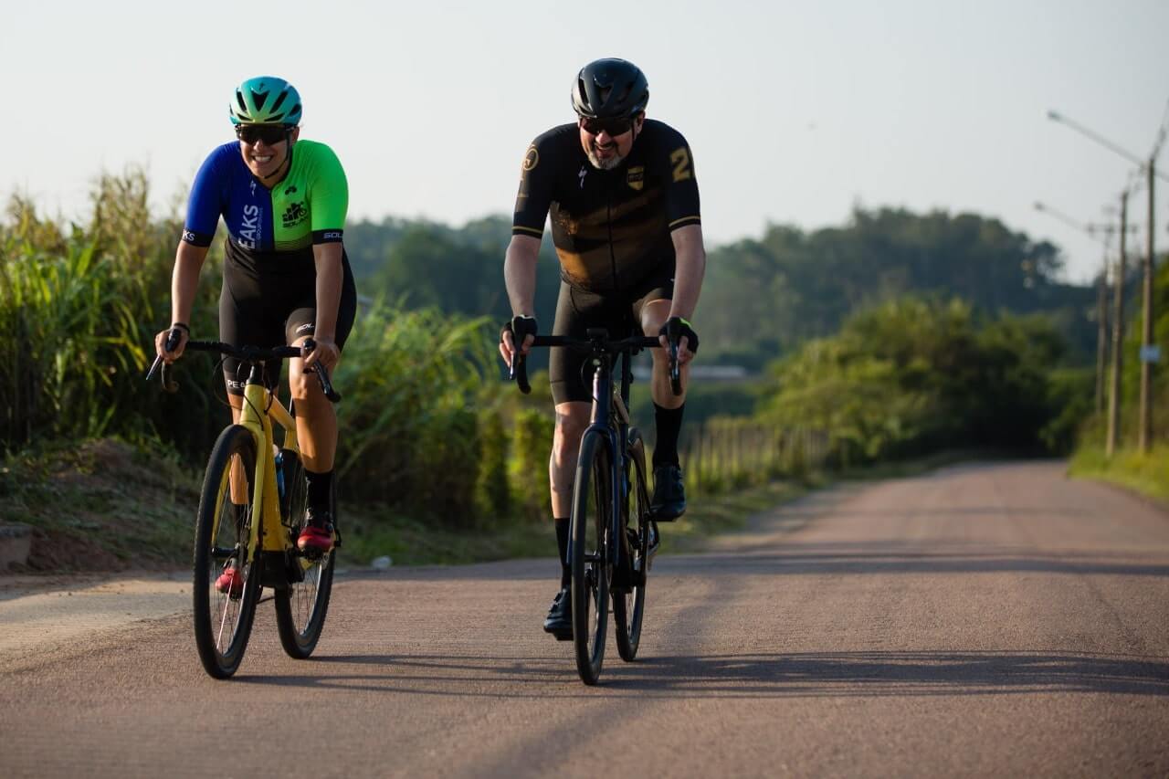 Dois homens em duas bicicletas em uma rodovia